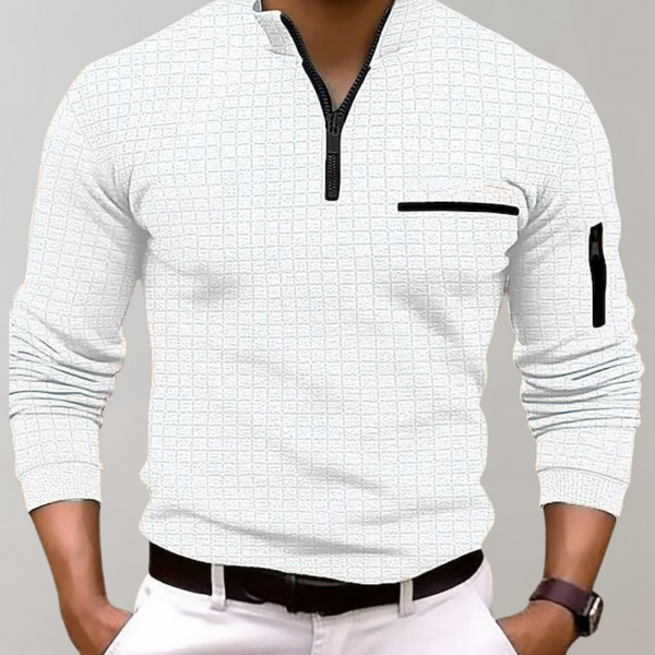 Homme portant un pull blanc à col zippé, motif quadrillé, avec poches zippées noires, manches longues, style décontracté et moderne.