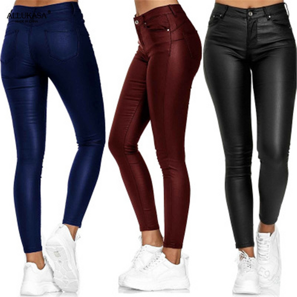 Trois femmes portant des leggings en cuir synthétique bleu, bordeaux et noir, avec des baskets blanches. Mode féminine, pantalons tendance.
