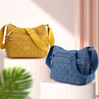 Deux sacs à bandoulière en tissu, jaune et bleu, avec poches zippées, posés sur des socles. Accessoires de mode tendance pour femmes.