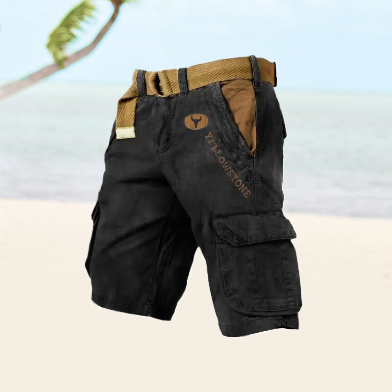 Short cargo noir "Yellowstone" avec ceinture marron, poches latérales, sur une plage tropicale. Mode estivale, vêtements décontractés pour homme.