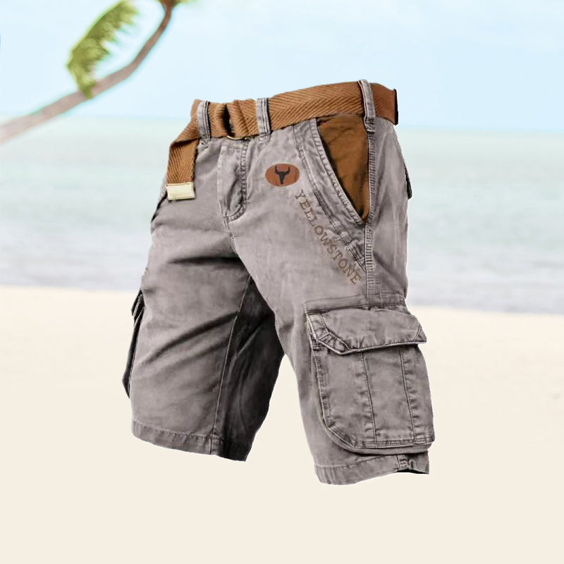Short cargo gris avec ceinture marron, poches latérales, logo Yellowstone, sur fond de plage tropicale. Mode estivale, vêtements décontractés.