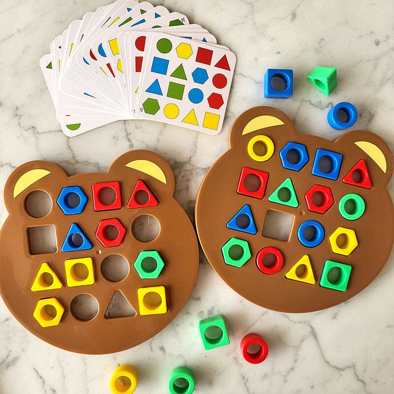 Jeu éducatif pour enfants avec formes géométriques colorées sur plateaux ours en bois, cartes d'activités sur fond marbre. Apprentissage ludique.
