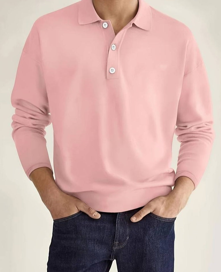 Homme portant un polo rose à manches longues avec boutons, associé à un jean bleu foncé. Mode masculine élégante et décontractée.