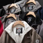 Vestes polaires à capuche pour homme, marque Norway, en différentes couleurs sur cintres en bois. Confortables, chaudes, idéales pour l'hiver.