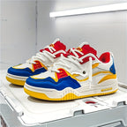 Chaussures de sport multicolores avec semelle épaisse, détails rouges, bleus et jaunes, posées sur une boîte blanche. Design moderne et tendance.