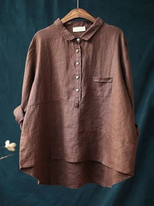 Chemise en lin marron pour femme, manches longues, col boutonné, poche poitrine, style décontracté, suspendue sur un cintre en bois.