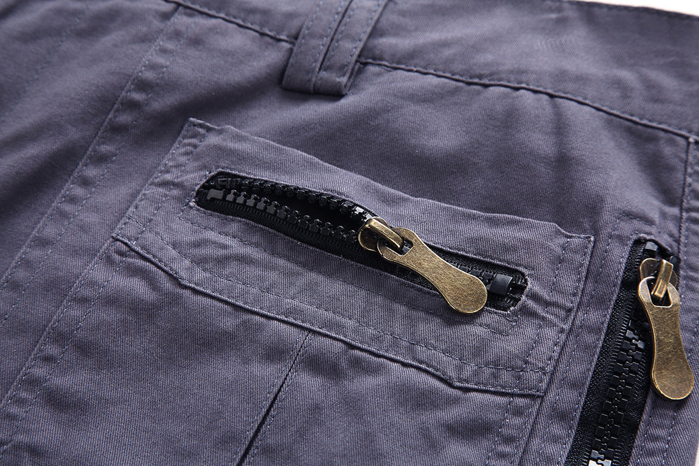 Pantalon gris avec poches zippées en métal doré, tissu résistant, style décontracté. Mode homme, vêtements durables, fermeture éclair robuste.