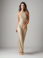 Femme portant une combinaison dorée scintillante, posant sur fond neutre. Mode élégante, tenue de soirée glamour, style chic et moderne.