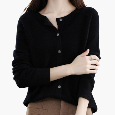 Femme portant un cardigan noir en laine, manches longues, avec boutons, sur fond blanc. Mode automne-hiver, tenue élégante et confortable.