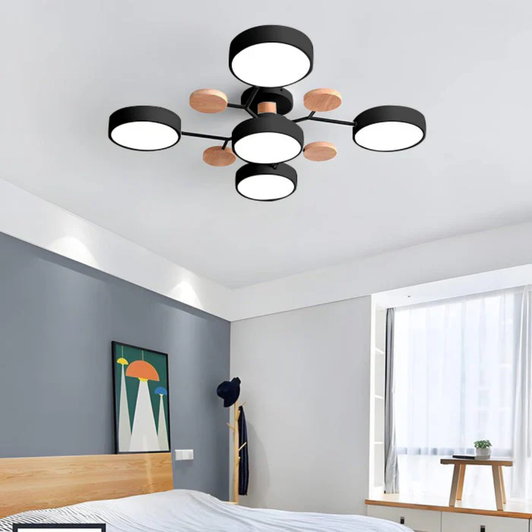 Plafonnier moderne noir et bois à cinq lumières LED, installé dans une chambre contemporaine avec mur gris, lit en bois et grande fenêtre.