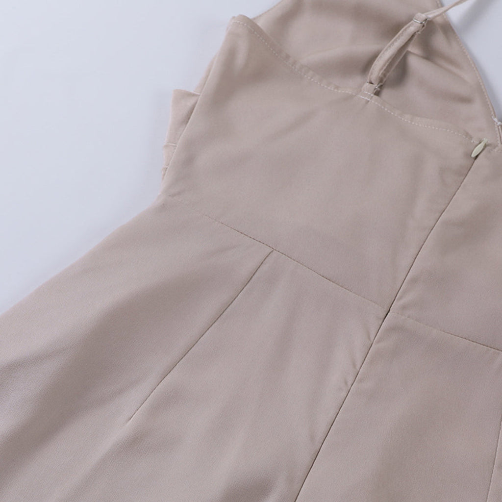 Robe beige élégante en tissu doux, avec bretelles fines et couture soignée, posée à plat sur fond blanc. Mode féminine, tenue chic.