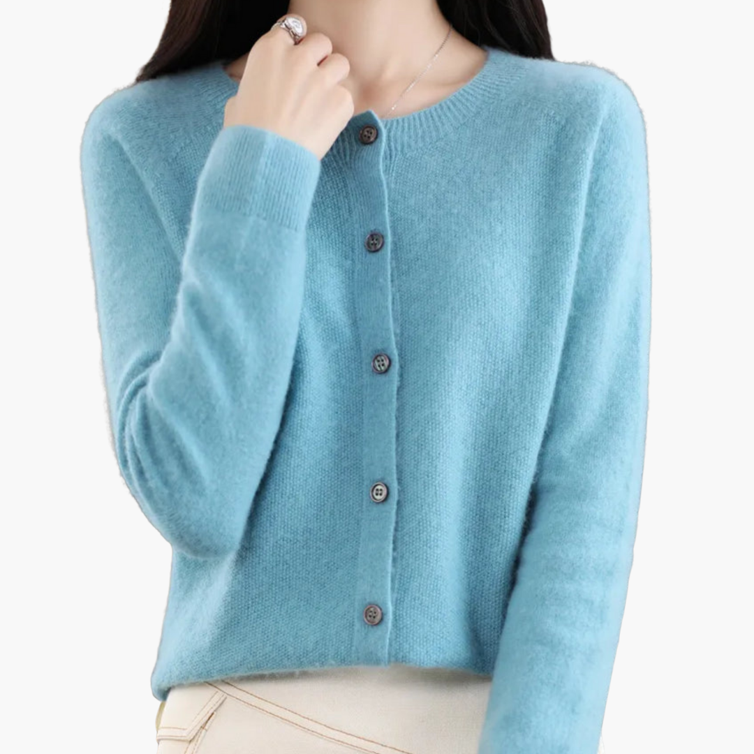 Femme portant un cardigan bleu en cachemire, manches longues, boutons noirs, style élégant et moderne. Mode automne-hiver, vêtement chaud et doux.