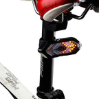 Tige de selle de vélo avec feu arrière LED clignotant, design flèche, sécurité cycliste, accessoire vélo moderne, éclairage nocturne efficace.