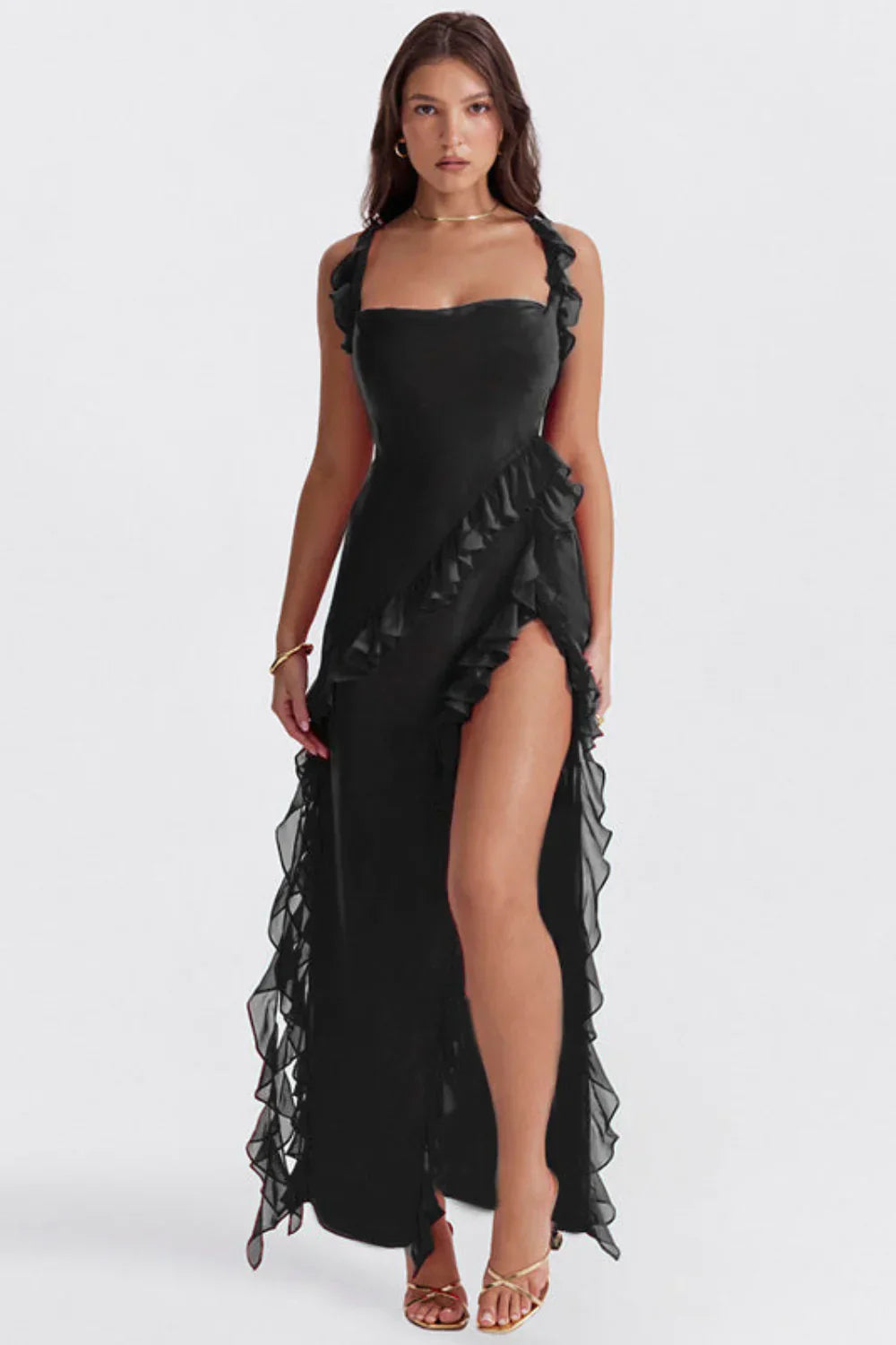 Robe noire élégante avec volants, fente haute, portée par une femme. Mode soirée chic, tendance, glamour.