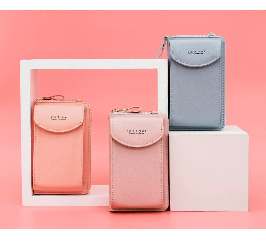 Trois portefeuilles en cuir pastel, rose et bleu, posés sur des cubes blancs, fond rose. Accessoires mode élégants et tendance.