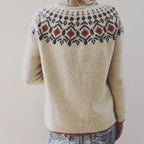 Pull en laine beige avec motif nordique coloré sur le dos, porté par une personne de dos. Mode hiver, tricot artisanal, style scandinave.