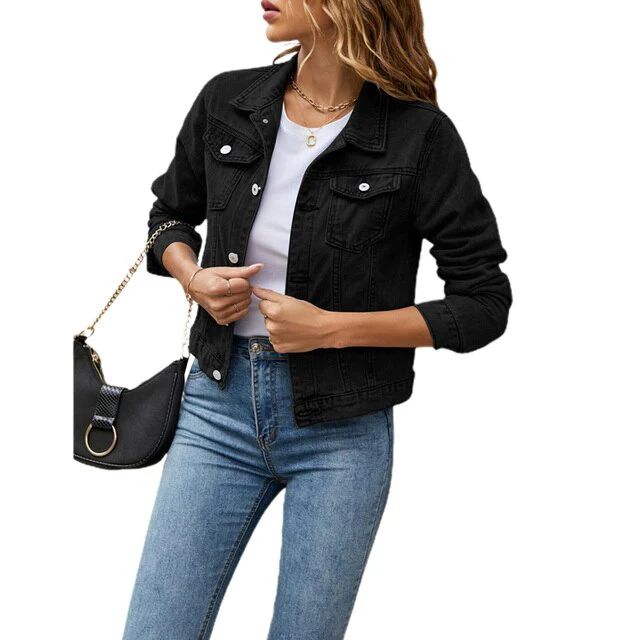 Femme portant une veste en jean noire, t-shirt blanc et jean bleu, tenant un sac à main noir. Mode décontractée, tendance automne.