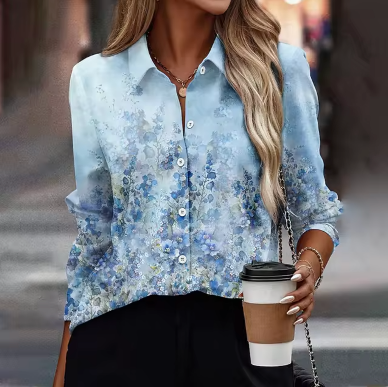 Femme portant une chemise à motifs floraux bleus, tenant un café à emporter. Mode élégante, style urbain, tenue décontractée chic.