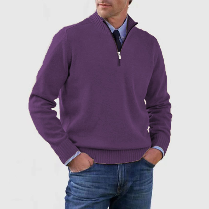 Homme portant un pull violet à col zippé, manches longues, sur une chemise bleue, avec un jean. Mode masculine élégante et décontractée.