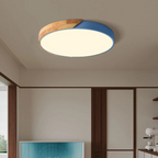 Plafonnier LED rond moderne en bois et bleu, éclairage intérieur design, monté au plafond d'un salon contemporain.