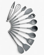 Ustensiles de cuisine en silicone gris, comprenant pince, fouet, pinceau, cuillères et spatules, sur fond blanc. Accessoires de cuisine modernes.