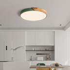 Plafonnier moderne rond en bois et vert dans une cuisine minimaliste blanche, éclairage LED, design contemporain, intérieur élégant et épuré.