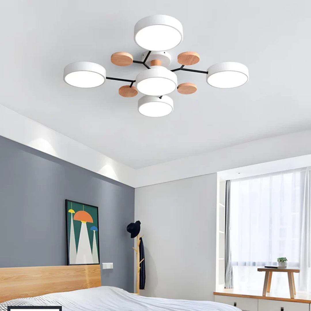 Plafonnier moderne à LED avec design circulaire et accents en bois, installé dans une chambre contemporaine avec mur gris et grande fenêtre.