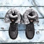 Bottes d'hiver noires avec doublure en fausse fourrure grise sur fond de neige, chaussures chaudes et imperméables pour temps froid.