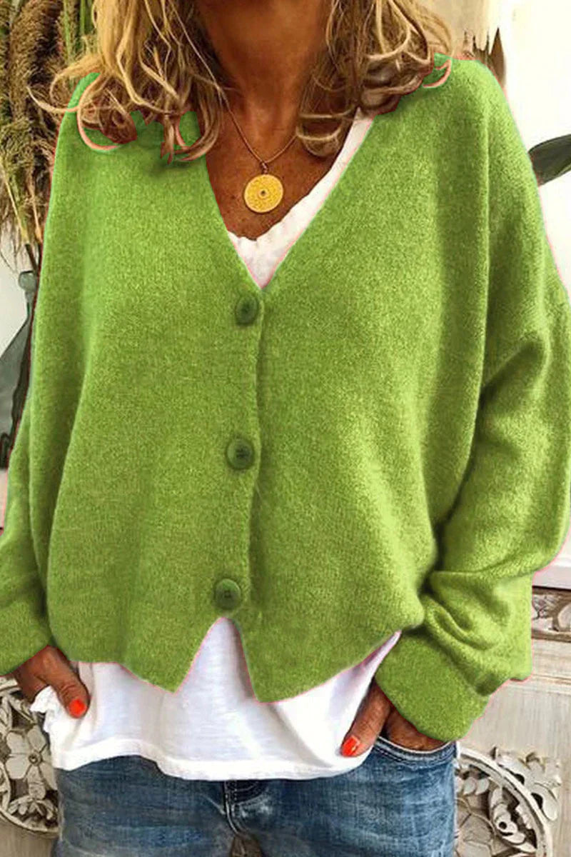 Femme portant un cardigan vert en laine avec boutons, sur un t-shirt blanc et un jean. Mode automne, style décontracté, tendance vêtements chauds.