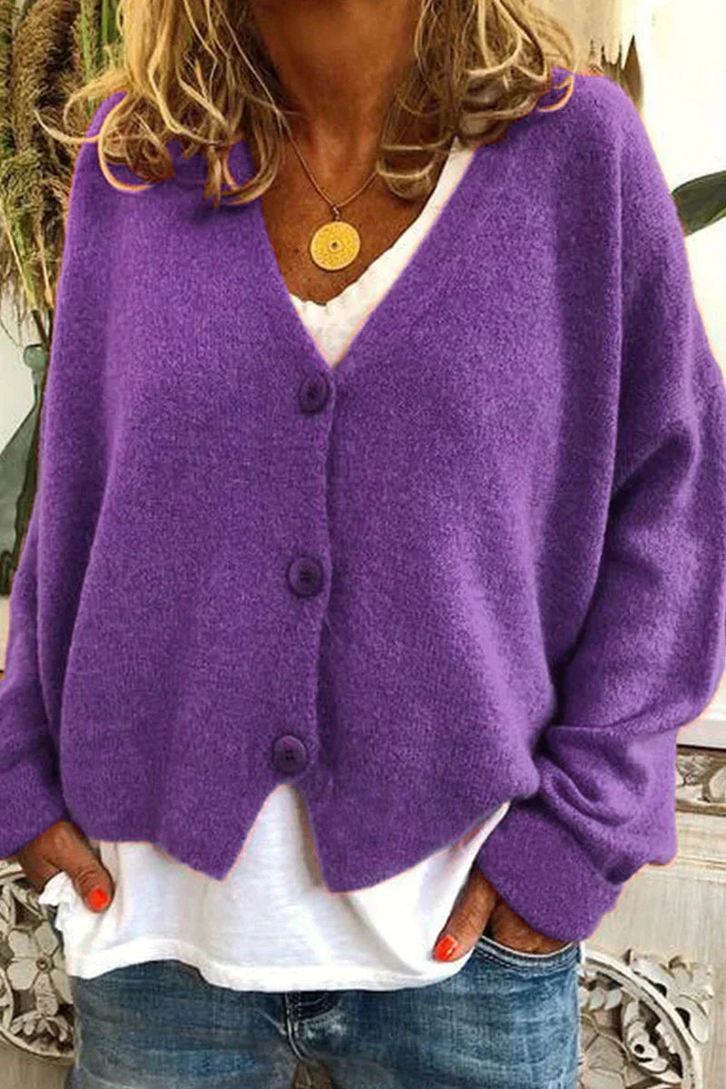 Femme portant un cardigan violet en laine avec boutons, sur un t-shirt blanc et un jean. Mode automne, style décontracté, tendance féminine.