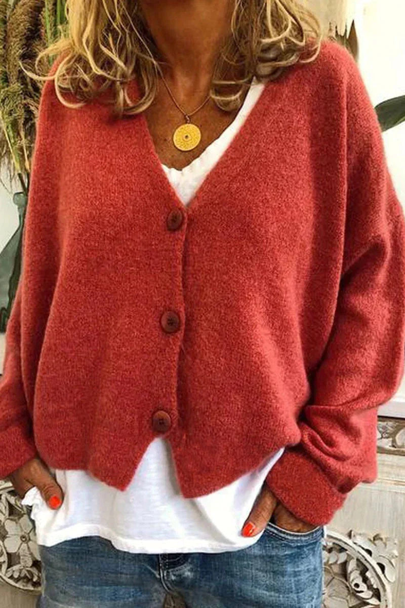 Femme portant un cardigan rouge en laine avec boutons, sur un t-shirt blanc et un jean. Mode automne, style décontracté, tendance féminine.