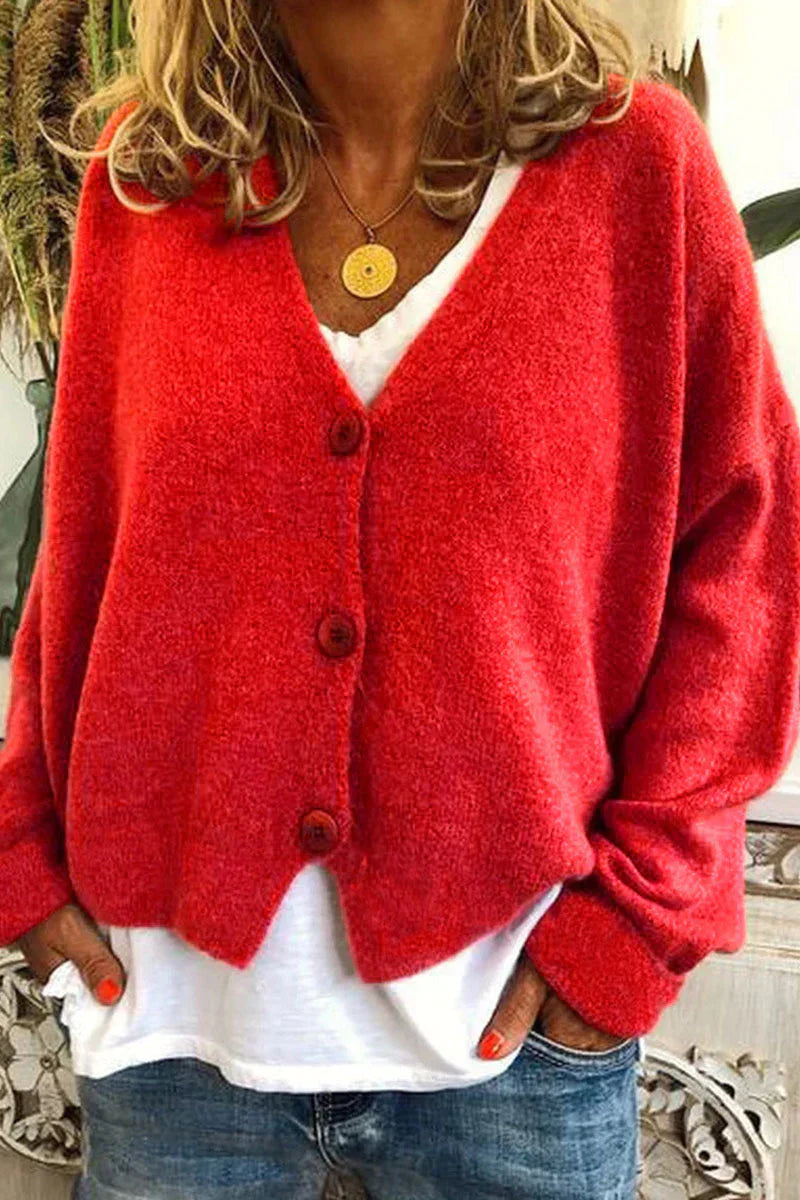 Femme portant un cardigan rouge en laine avec boutons, sur un t-shirt blanc et un jean. Mode automne, style décontracté, tendance féminine.