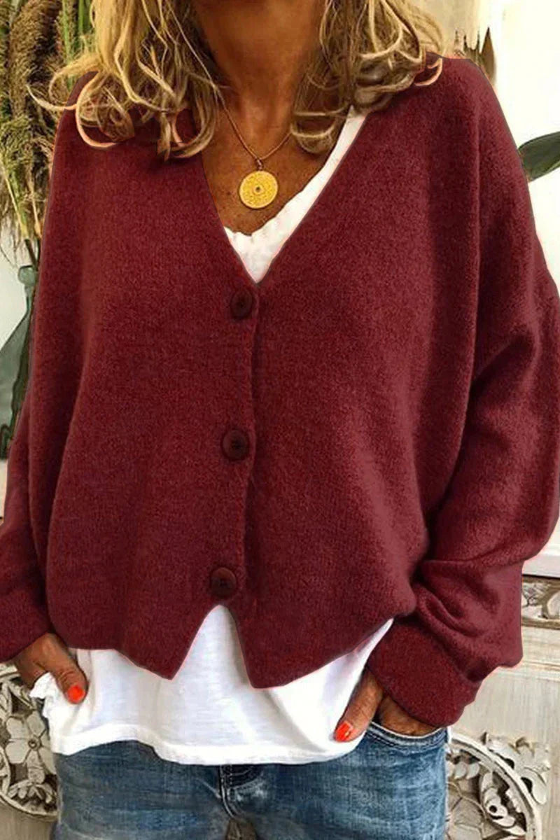 Femme portant un cardigan bordeaux en laine avec boutons, sur un t-shirt blanc, et un jean bleu. Mode automne, style décontracté, tendance féminine.
