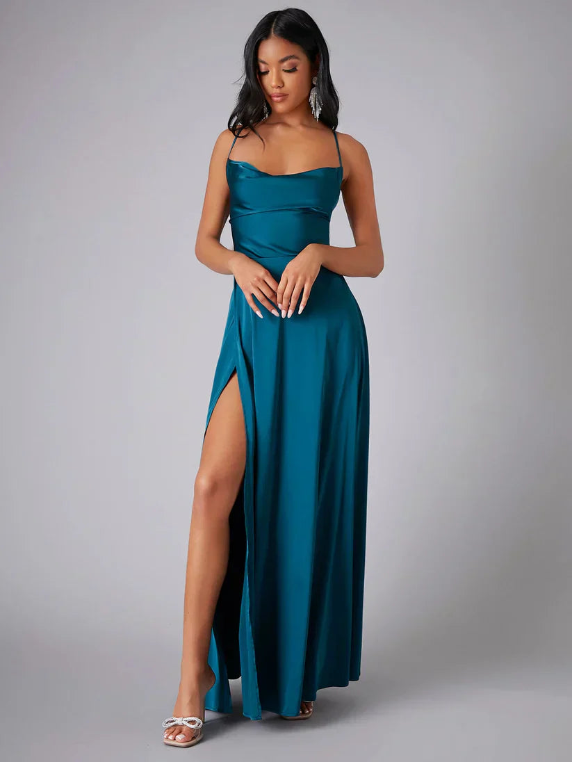 Robe de soirée longue bleu sarcelle avec fente haute, bretelles fines, portée par une femme. Élégante et moderne, idéale pour événements formels.