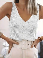 Femme portant un débardeur à paillettes argentées, pantalon blanc taille haute avec ceinture. Mode élégante, tenue de soirée chic.
