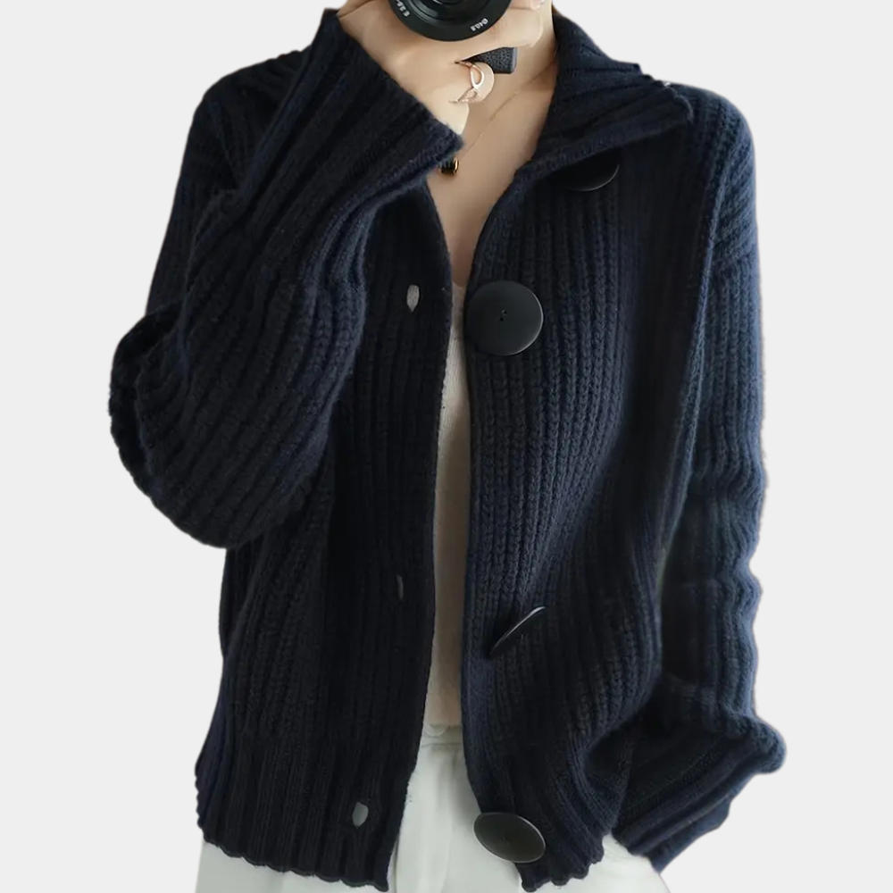 Gilet en maille côtelée bleu marine avec gros boutons noirs, porté par une personne. Mode automne-hiver, style décontracté et élégant.