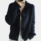 Gilet en maille côtelée bleu marine avec gros boutons noirs, porté par une personne. Mode automne-hiver, style décontracté et élégant.