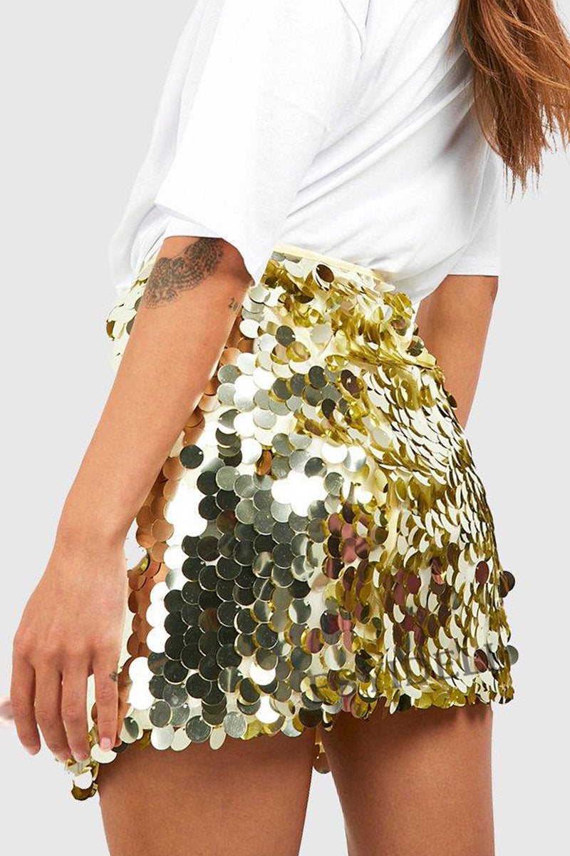 Femme portant une jupe à sequins dorés étincelants, associée à un t-shirt blanc. Mode tendance, style glamour, tenue de soirée chic.