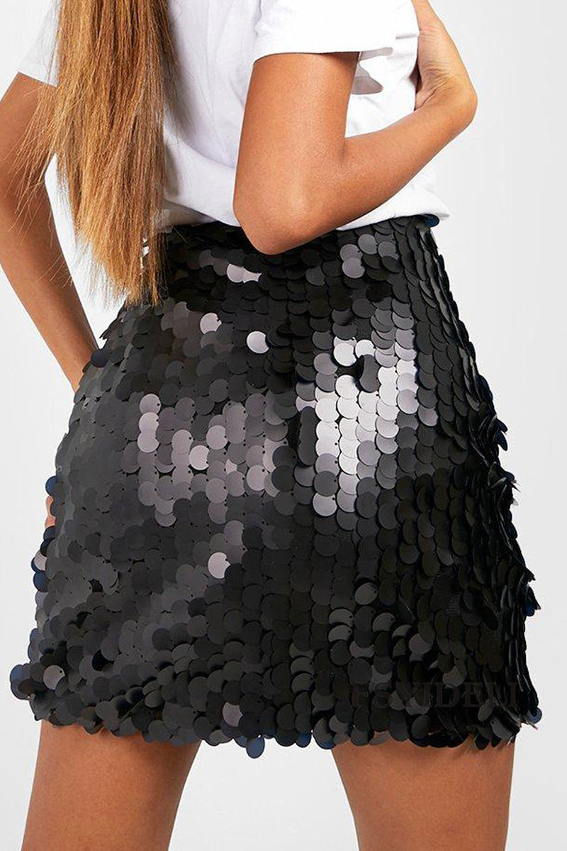 Femme portant une jupe à sequins noirs brillants, associée à un t-shirt blanc. Mode tendance, tenue de soirée élégante et moderne.