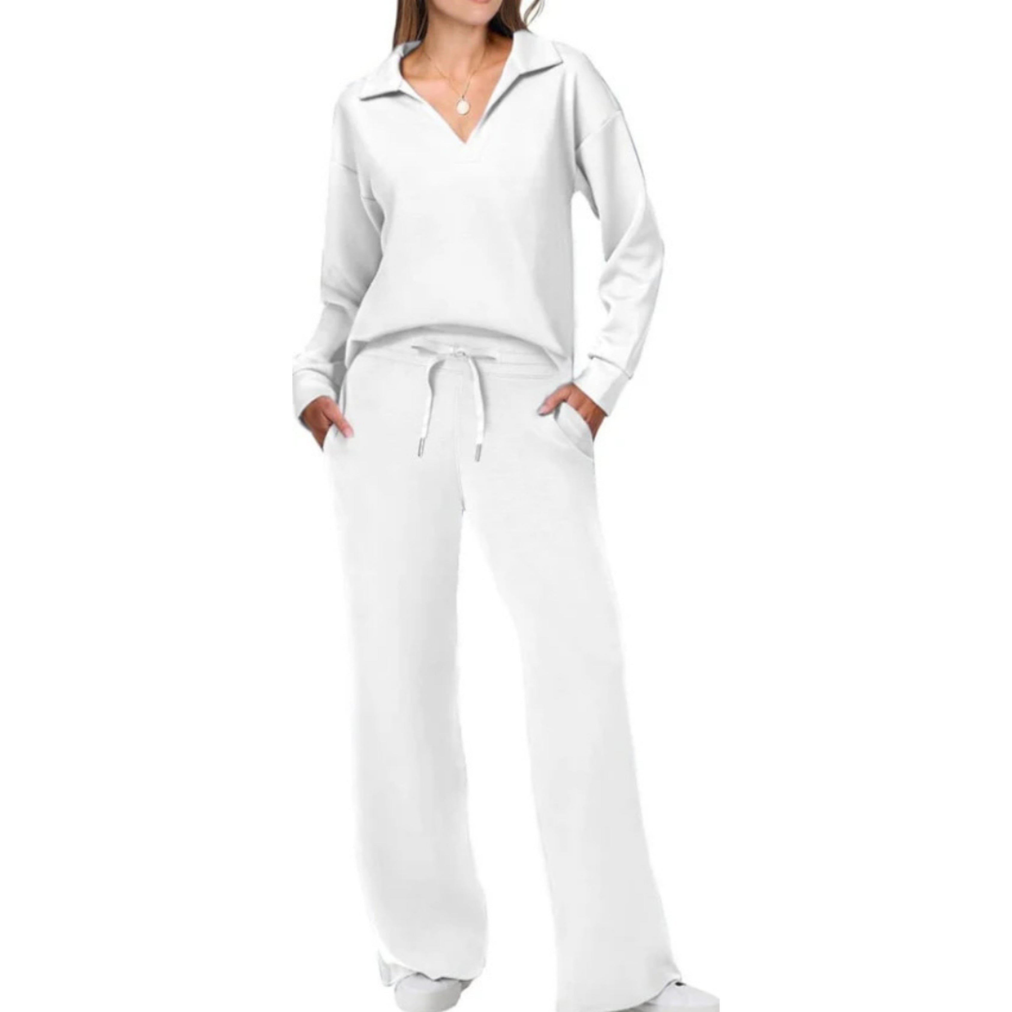 Femme portant un ensemble de survêtement blanc, composé d'un pull à col en V et d'un pantalon ample avec cordon, style décontracté et moderne.