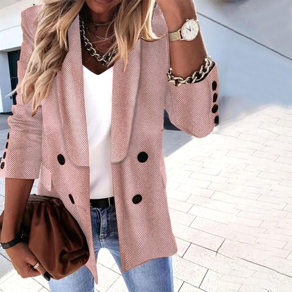 Blazer femme rose à chevrons, manches retroussées, boutons noirs, porté avec un top blanc, jean bleu, sac marron et montre dorée. Mode élégante.