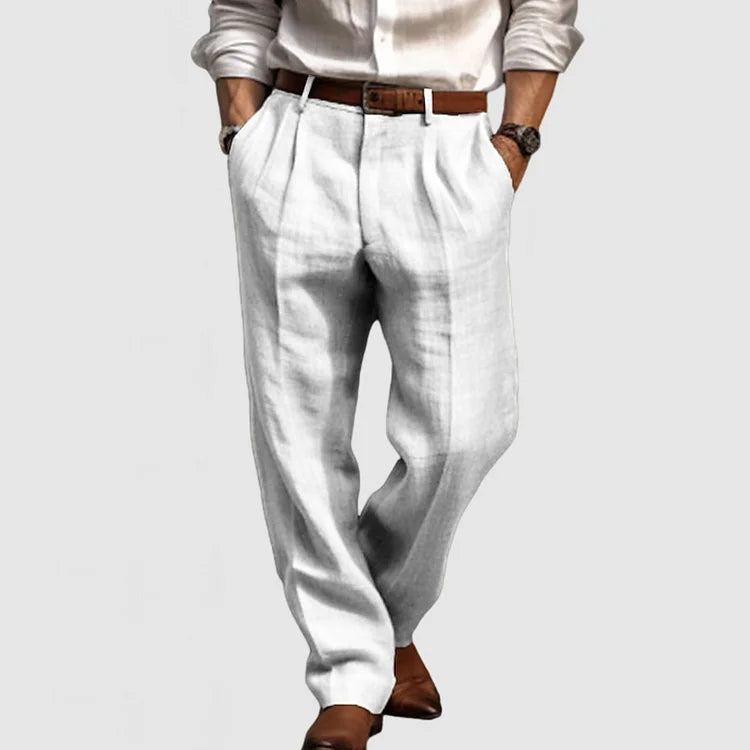 Homme portant un pantalon en lin blanc élégant, chemise blanche, ceinture marron et chaussures en cuir marron. Mode masculine chic et décontractée.