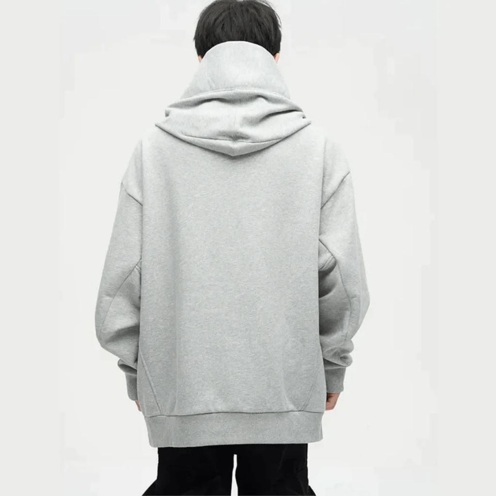 Homme portant un sweat à capuche gris oversize, vu de dos. Mode décontractée, tendance streetwear, vêtement confortable pour l'automne.
