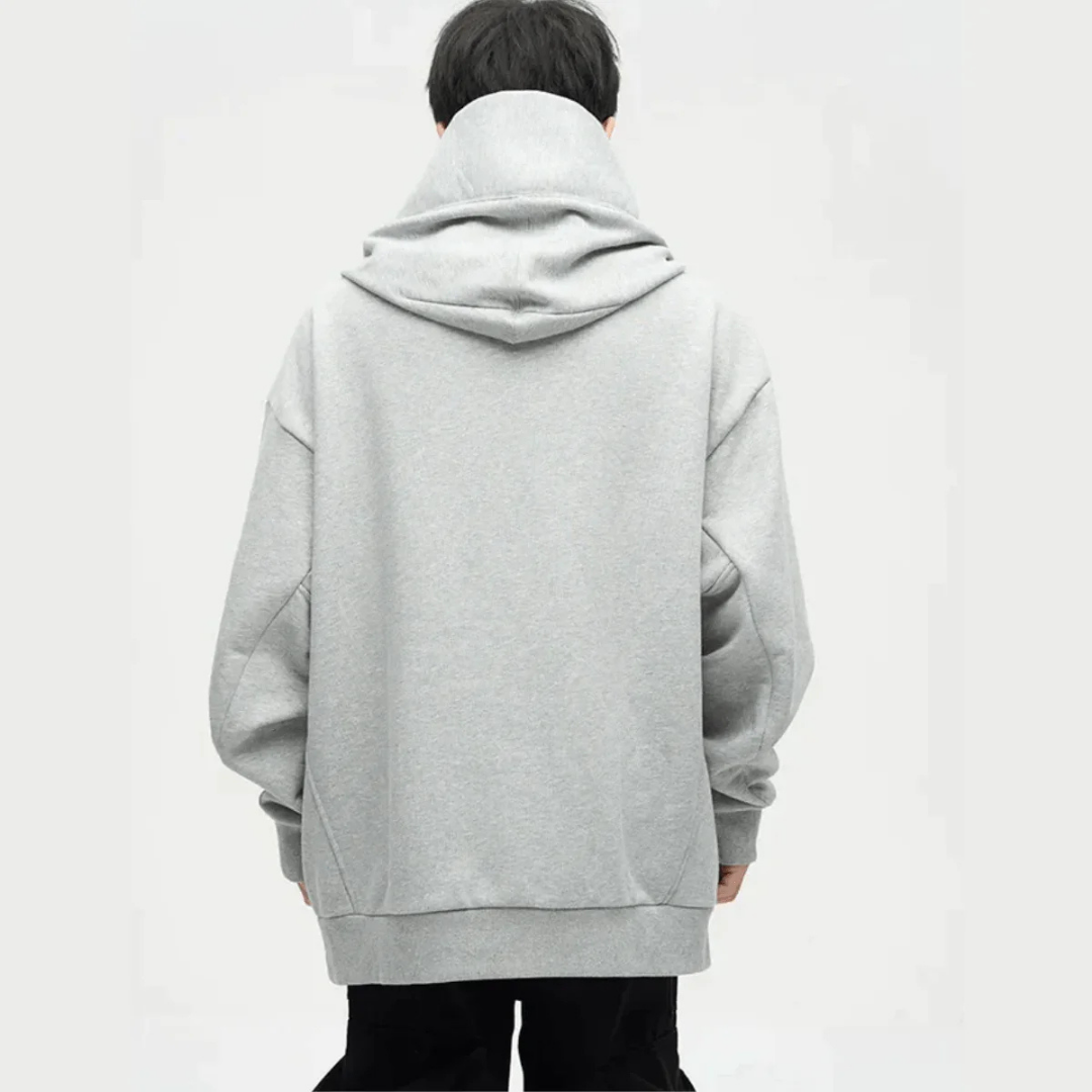 Homme portant un sweat à capuche gris oversize, vu de dos. Mode décontractée, tendance streetwear, vêtement confortable pour l'automne.