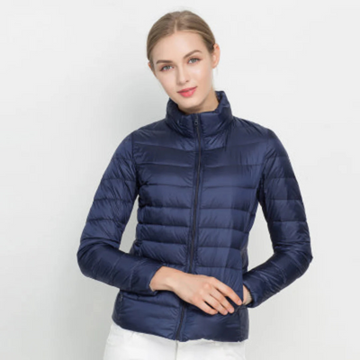 Femme portant une doudoune bleu marine, manches longues, fermeture éclair, sur fond blanc. Mode hiver, veste chaude, style décontracté.