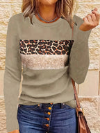 Femme portant un pull beige à motif léopard et paillettes, associé à un jean à boutons. Mode automne, style décontracté chic.