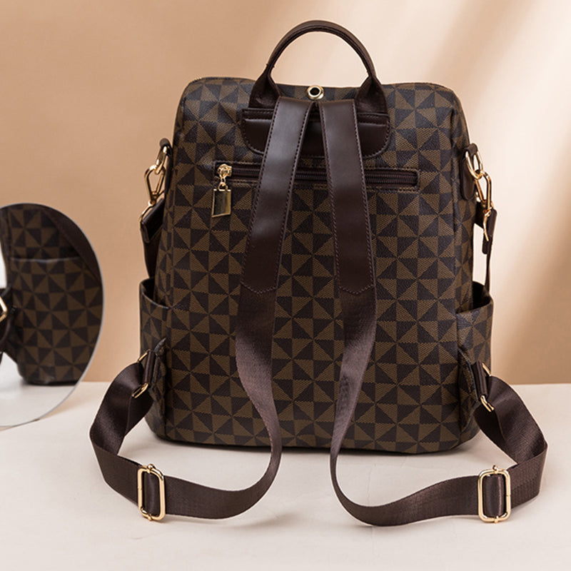 Sac à dos en cuir marron à motifs géométriques, avec bretelles ajustables et poches latérales, posé sur une surface beige. Accessoire mode élégant.