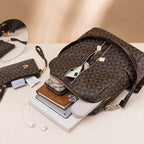 Sac à dos en cuir marron avec motif géométrique, ouvert, révélant des livres, un smartphone, écouteurs et accessoires. Mode, accessoires, organisation.