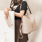 Femme avec sac à dos géométrique beige et pochette assortie, mode élégante, tenue décontractée, jupe plissée marron, intérieur moderne.