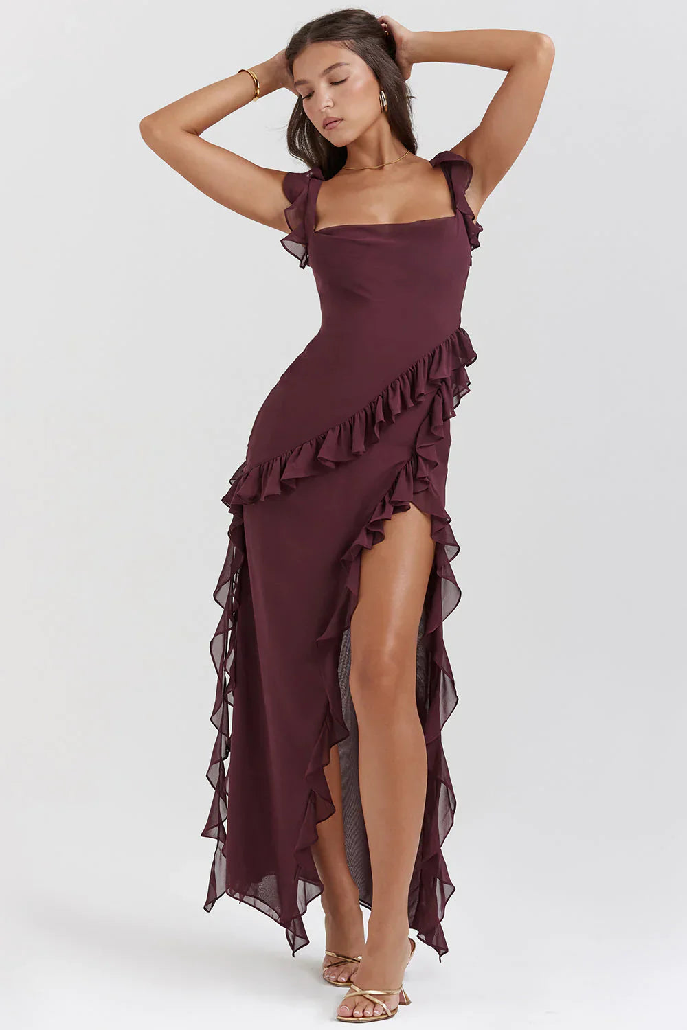 Robe longue bordeaux à volants, élégante et asymétrique, portée par une femme posant. Mode féminine, tenue de soirée chic.